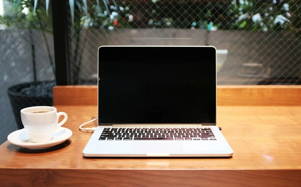 Digital nomad workspace with a laptop and coffee at an outdoor café table