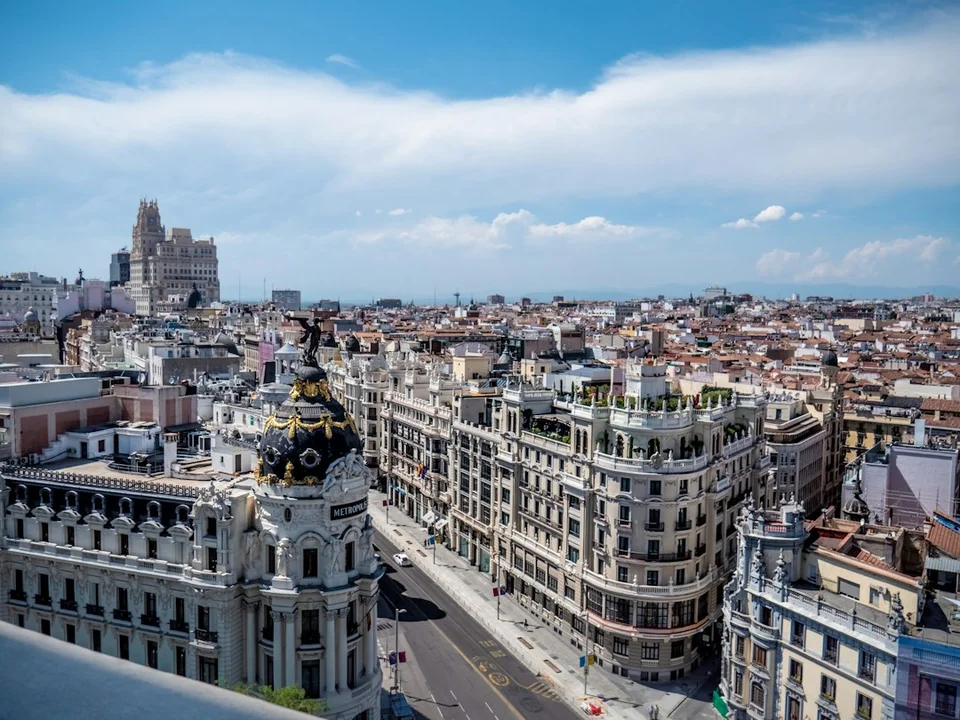 Aerial view of central Madrid with light-colored facades, clear sky and historic architecture.